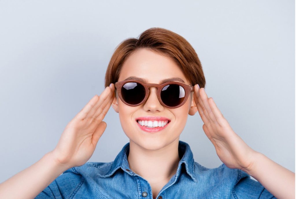 Woman smiles while wearing glasses reglazed with polarised lenses